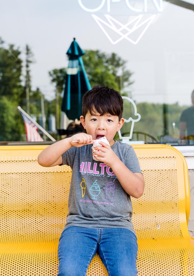 A child enjoying a cup of Hilltop ice cream outside the shop