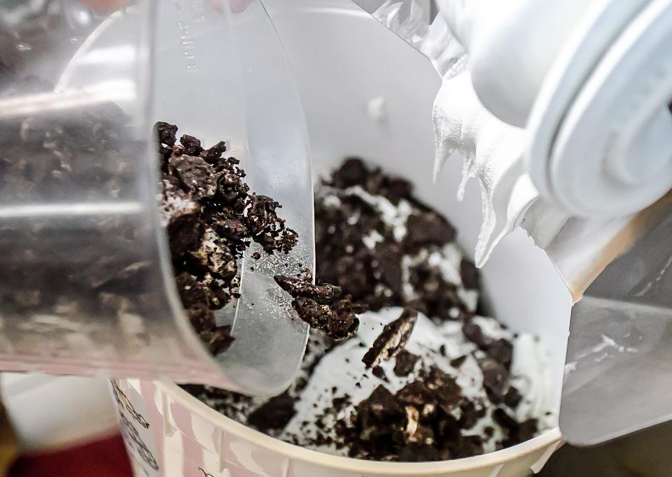 Cookies and cream ice cream being mixed with chocolate cookie pieces