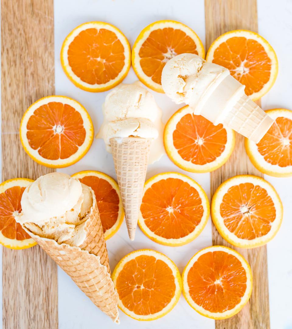Orange ice cream cones arranged on a pink surface